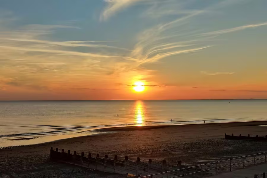 Golden sunset over the beach and Cardigan Bay from the promenade, Mid-Wales