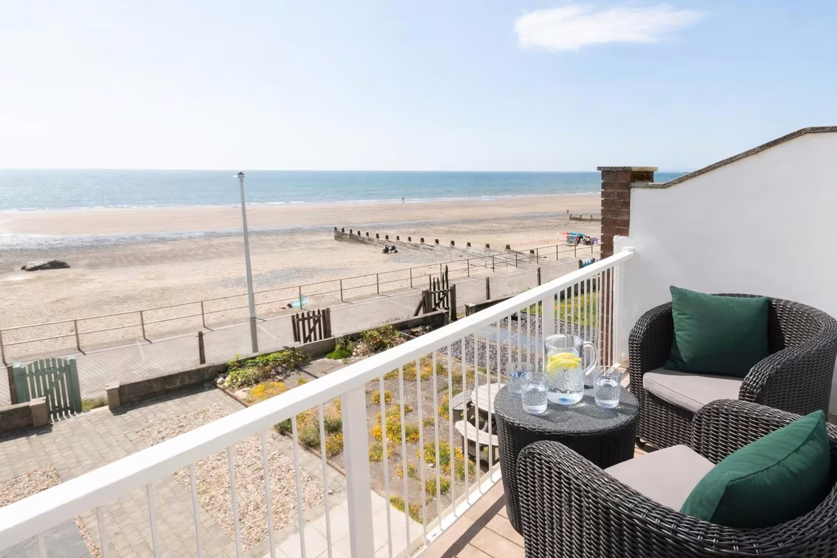 Four Degrees West – balcony with rattan seating overlooking the beach and Cardigan Bay